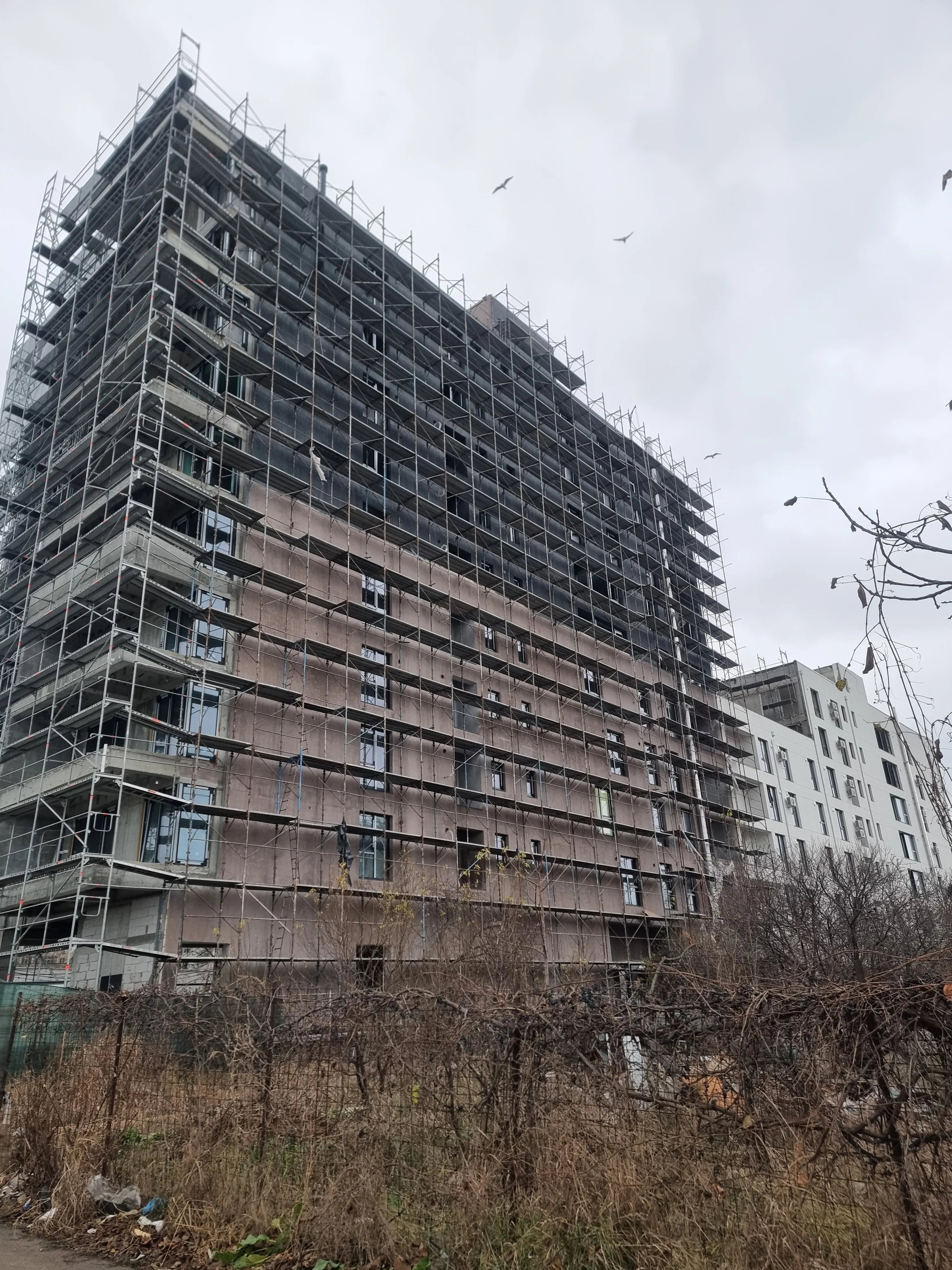 Schelă montată pe fațada unei clădiri cu mai multe niveluri.