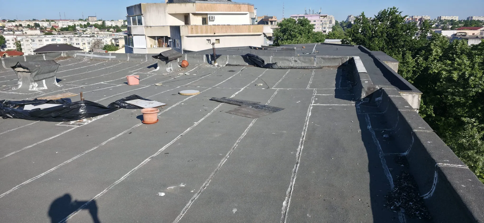 Terasă înainte de decopertare, cu membranele existente și intervenții vizibile la îmbinări și racorduri.